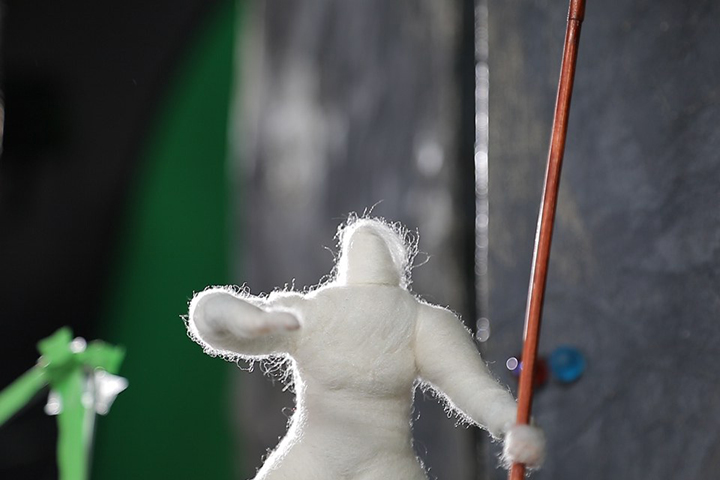 Unbearbeitete Filmaufnahme einer Filzwollepuppe vor Greenscreen im Animationsstudio